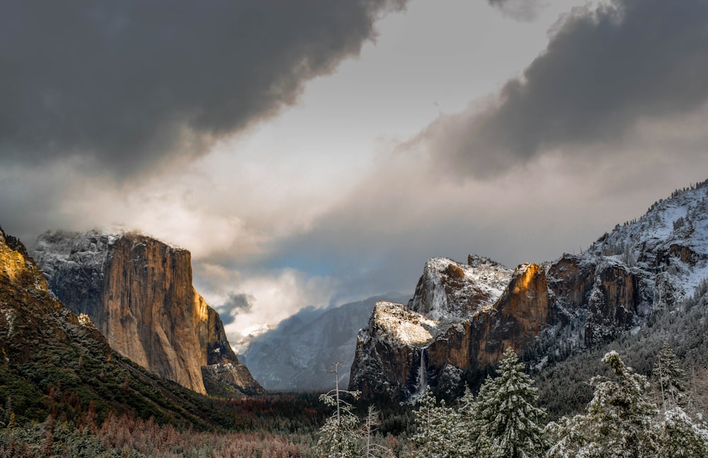 mountain covered with snow under black clouds during daytime