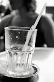 Refreshing cold drink with condensation droplets on the glass beside a meal tray.