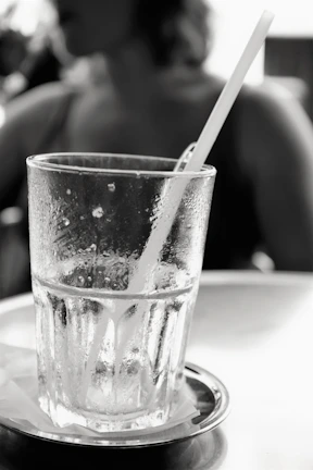 Refreshing cold drink with condensation droplets on the glass beside a meal tray.