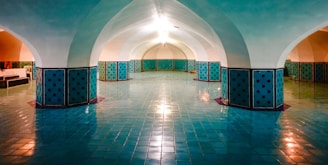 Spacious reception hall with warm earthy tones and elegant lighting set for an event.