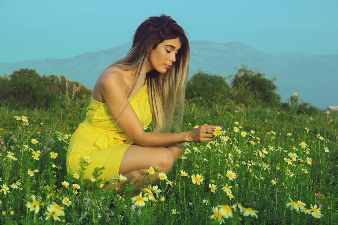 woman in yellow tank top on yellow flower field during daytime