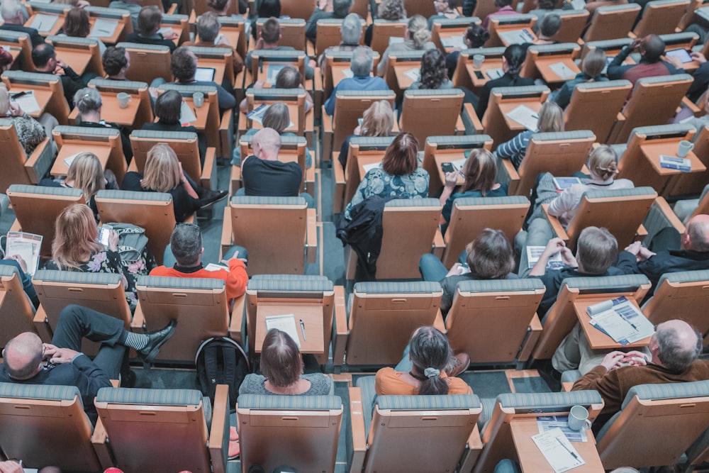 Photographie en plongée d’un groupe de personnes assises à des chaises