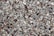 A large collection of small, smooth, and multi-colored pebbles closely packed together, showcasing variations in texture and size.