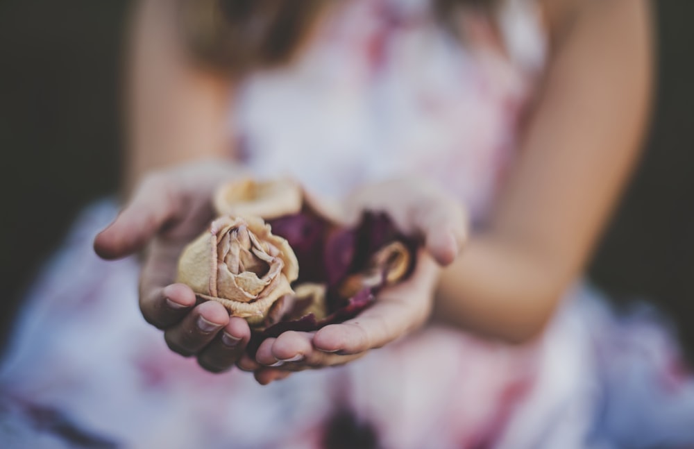 Fotografía de enfoque selectivo de una niña sosteniendo flores