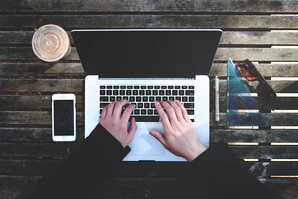 Flat-Lay-Fotografie einer Person, die im Begriff ist, einen Laptop zu benutzen