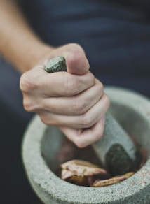 person grinding on mortar and pestle