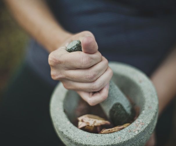 person grinding on mortar and pestle