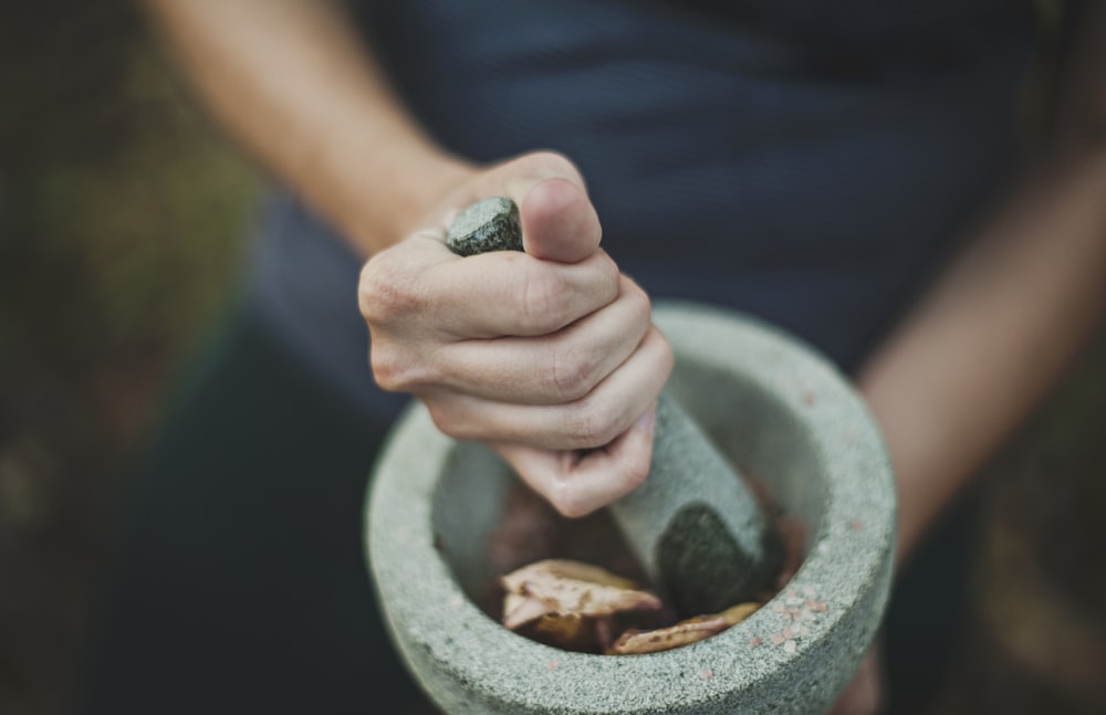 person grinding on mortar and pestle
