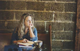 A candid photo of me deep in thought at a cozy café, notebook open.