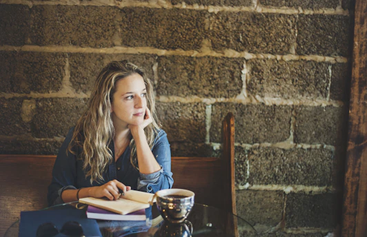 A candid photo of Sarah Edwards thoughtfully reviewing notes at a cozy café table.