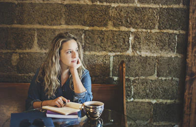 A candid photo of me deep in thought at a cozy café, notebook open.