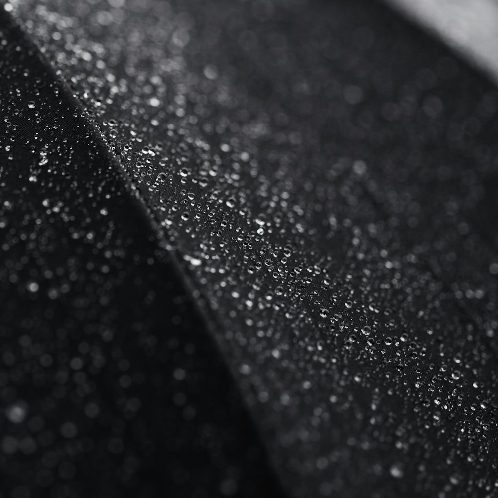 Foto macro de pequenas gotículas de água em uma superfície preta