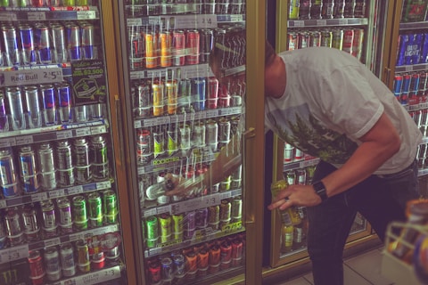 man getting can in beverage cooler
