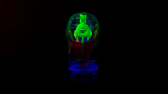 Close-up of a sleek black 3D printed object with glowing orange neon highlights on a dark background.