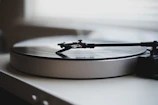 Close-up of a vintage turntable spinning a vinyl record under soft, warm lighting.