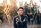 smiling man standing near green trees