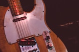 Close-up of a vintage electric guitar with worn paintwork.