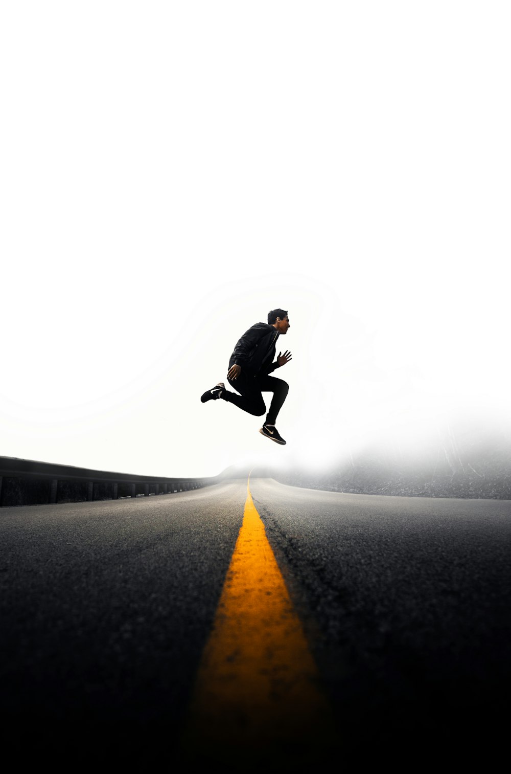 man jumping above gray and yellow concrete road at daytime