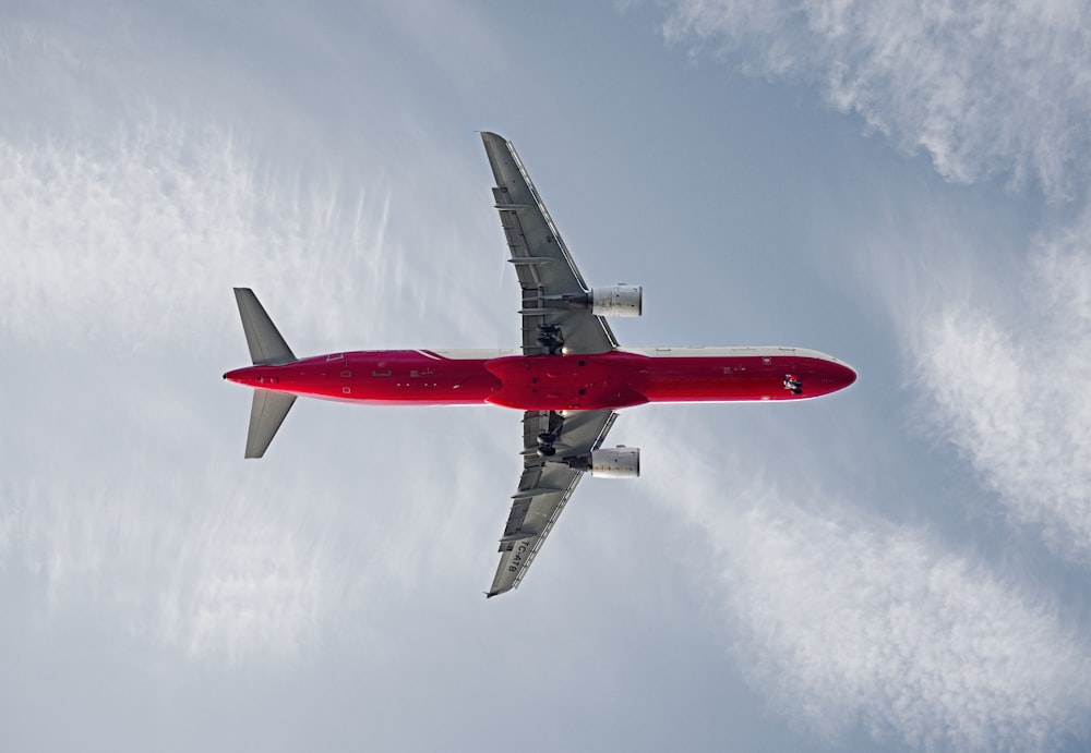 Avião de passageiros vermelho e branco no céu durante o dia