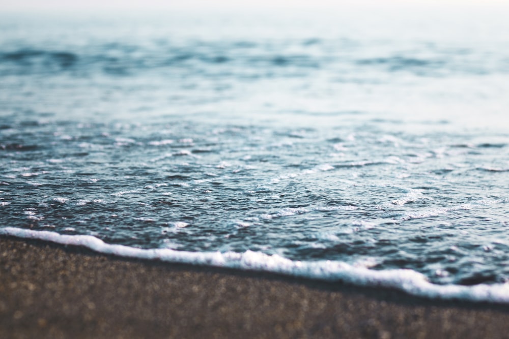 sea waves touches seashore at daytime