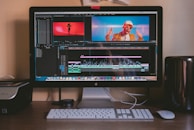 turned on iMac and Apple Magic Keyboard and mouse on table
