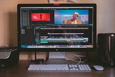 turned on iMac and Apple Magic Keyboard and mouse on table