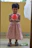 Smiling woman holding a colorful dress with a child playing with a soccer ball toy