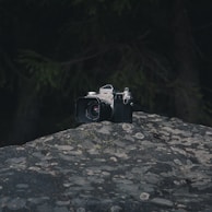 Close-up of a vintage camera resting on a textured dark surface with bronze highlights.