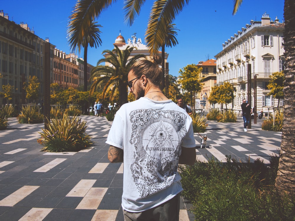 man standing near people, trees, and buildings