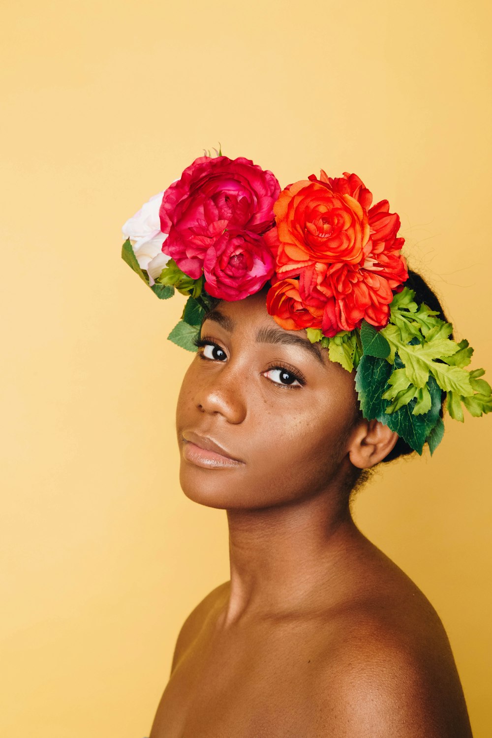 Uma mulher afro-americana com uma faixa de cabeça coberta de flores.