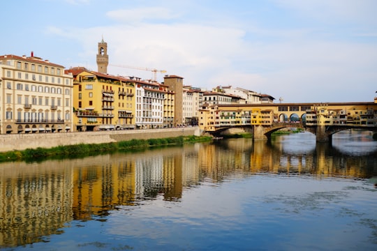 brown concrete building near river during daytime in Ponte Vecchio Italy