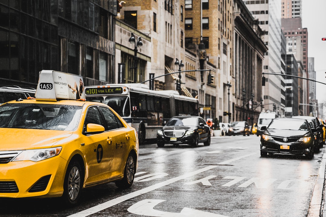 yellow taxi travelling on city streets