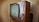 A vintage television set with a wooden frame and a rounded screen is displayed. The television features several knobs and buttons on the right side for manual adjustments. The design is reminiscent of mid-20th century electronics, highlighting its retro aesthetic.