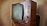 A vintage television set with a wooden frame and a rounded screen is displayed. The television features several knobs and buttons on the right side for manual adjustments. The design is reminiscent of mid-20th century electronics, highlighting its retro aesthetic.
