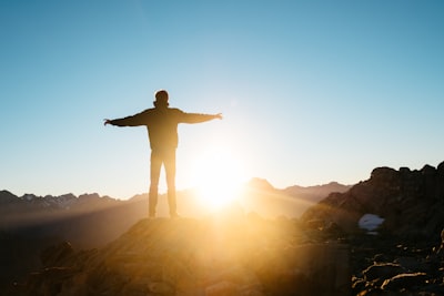 person standing on hill person teams background