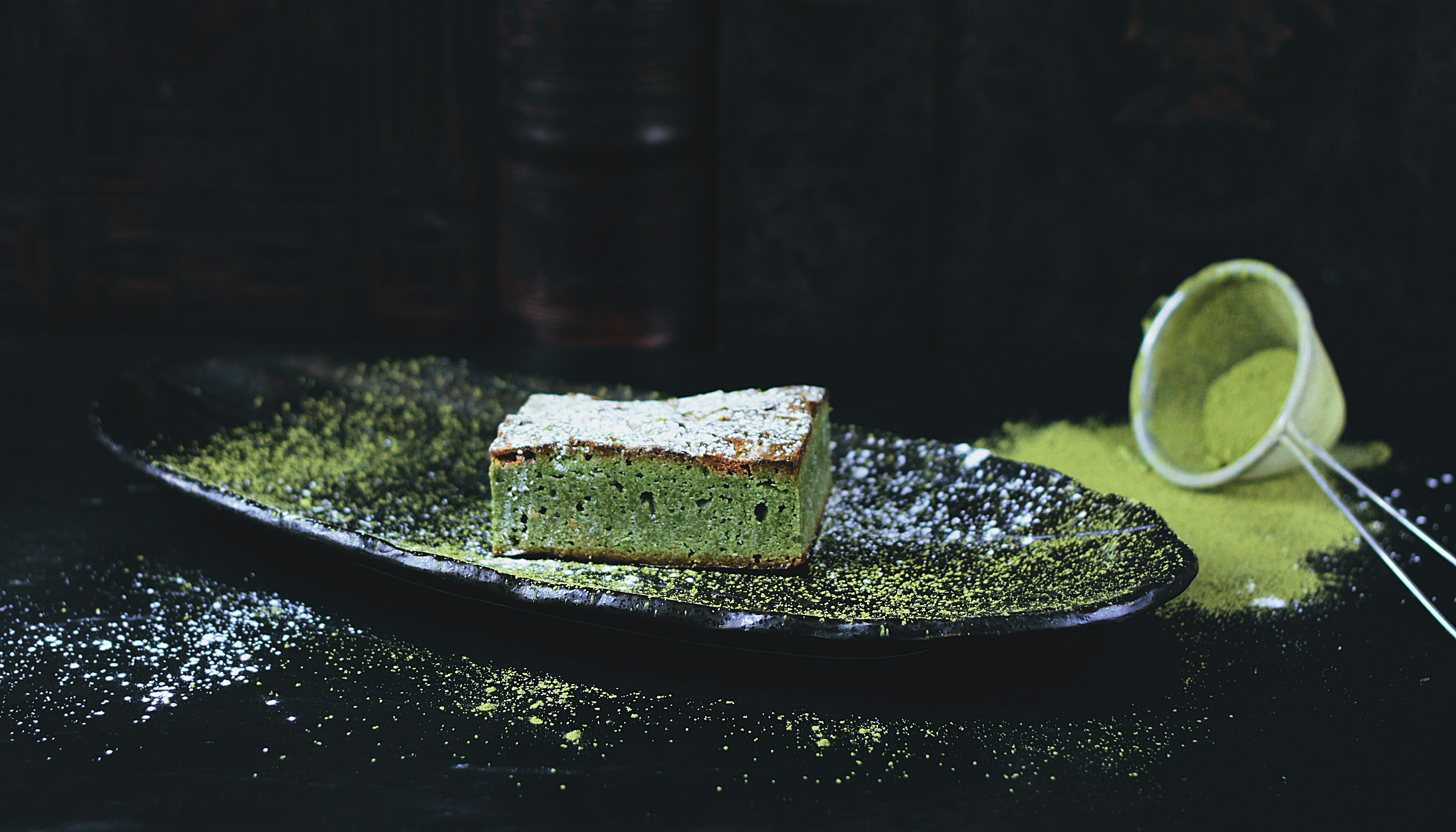 green and brown sponge cake on black oval plate