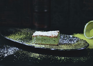 green and brown sponge cake on black oval plate