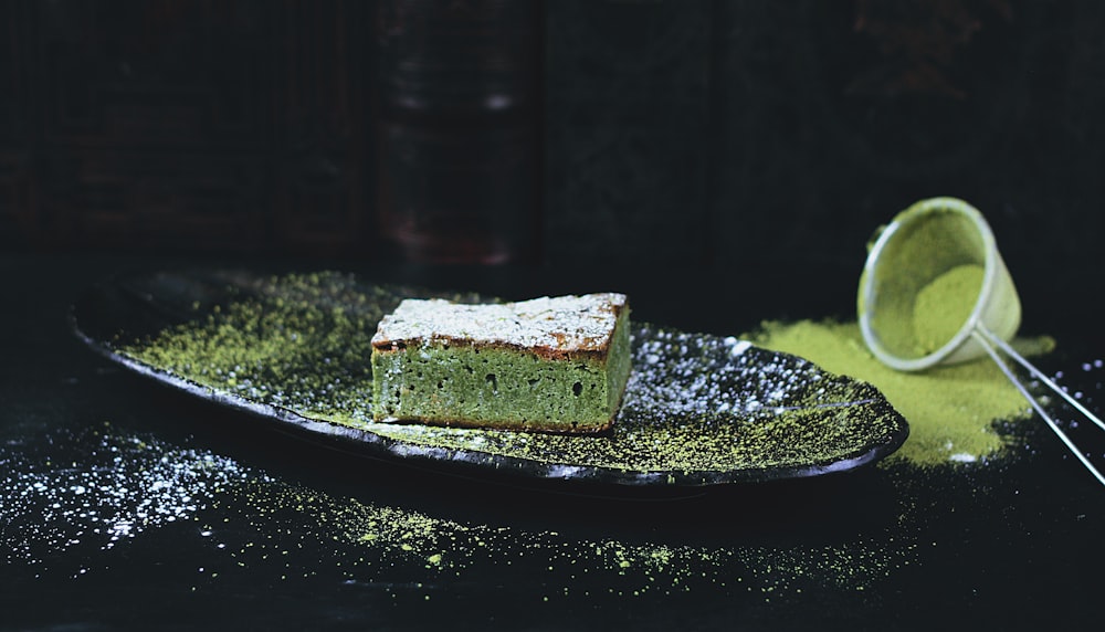 green and brown sponge cake on black oval plate