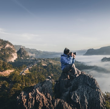 man on top of mountain taking pictures