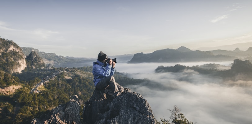 man on top of mountain taking pictures