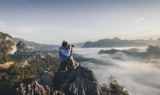 man on top of mountain taking pictures