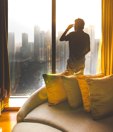 An elegant penthouse overlooking a city skyline, bathed in warm golden light.