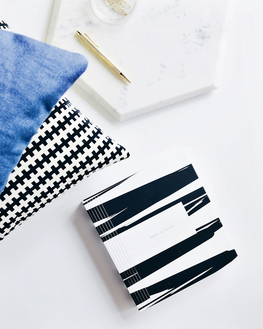 gray retractable pen beside blue textile