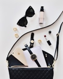 women's sunglasses and black bag with watch and iPhone 6