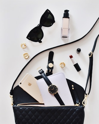 women's sunglasses and black bag with watch 