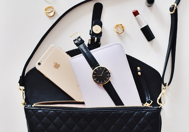 women's sunglasses and black bag with watch and iPhone 6