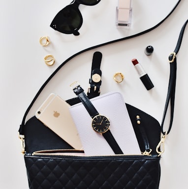 women's sunglasses and black bag with watch and iPhone 6