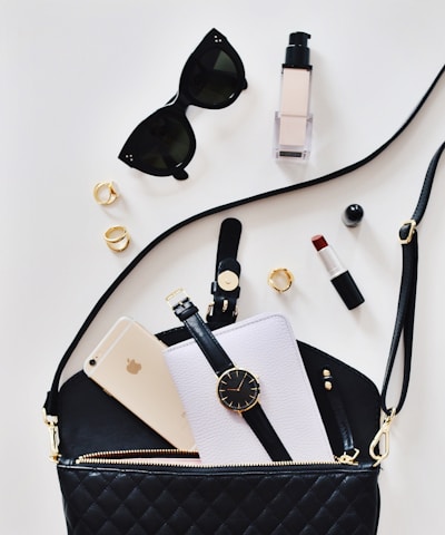 women's sunglasses and black bag with watch and iPhone 6