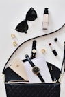 women's sunglasses and black bag with watch and iPhone 6