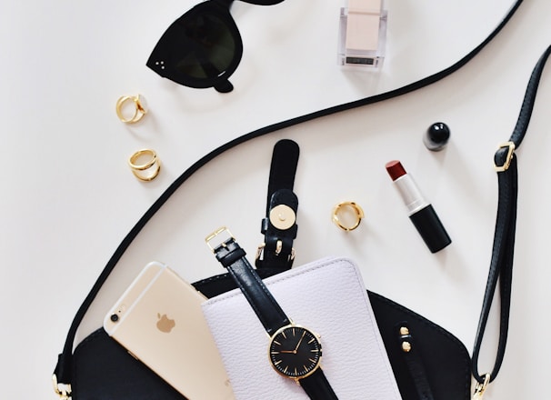 women's sunglasses and black bag with watch and iPhone 6